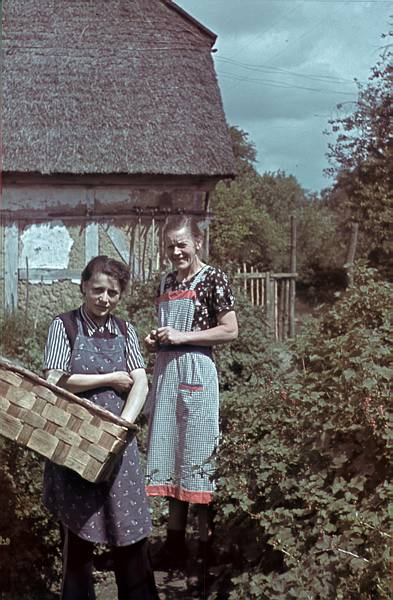 1940. Mecklenburg-Vorpommern. Darß. Ostsee. Zwei Frauen vor einem reetdachgedeckten Haus.
