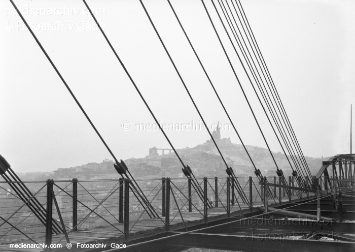 1932. Frankreich.  Marseille.  Le Pont à Transbordeur. Schwebebrücke.
1932. Frankreich.  Provence-Alpes-Côte dAzur. Marseille. Hafenstadt am Golfe du Lion, einer Mittelmeerbucht.   Le Pont à Transbordeur. Schwebebrücke. 
Schlüsselwörter: 1932;Frankreich;Marseille;Provence-Alpes-Côte dAzur;Hafenstadt;France;Le Pont à Transbordeur;Schwebebrücke