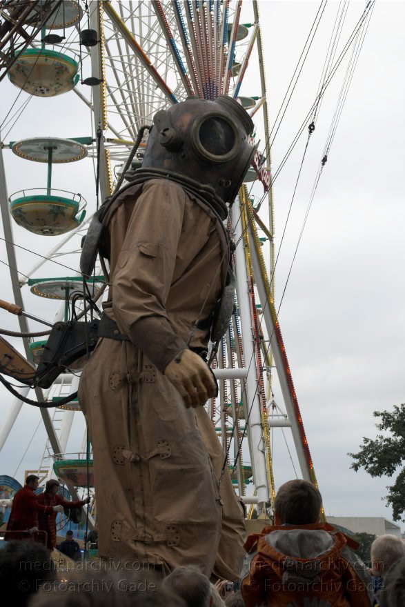 Berlin. Royal de Luxe. Taucher und Riesenrad
3. 10. 2009. Berlin. Mitte. Tiergarten. Straße des 17. Juni. Royal de Luxe. Straßentheater mit riesigen Marionetten. Puppen. Tiefseetaucher
Schlüsselwörter: Berlin;Deep-Sea-Diver;Deutschland;diver;Germany;marionette;Royal de Luxe;Straßentheater;street theatre;Theater;Tiefseetaucher;2009;Tiergarten;Straße des 17 Juni