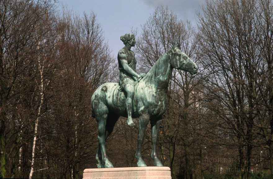 Berlin. Tiergarten. Bronzeskulptur. Frau auf einem Pferd. Reiterin. Reiten.
Januar 1992. Berlin. Mitte. Tiergarten. Bronzeskulptur. Frau auf einem Pferd. Reiterin. Reiten.
Schlüsselwörter: Berlin;Bronzeskulptur;Deutschland;Frau;Germany;Pferd;Reiten;Reiterin;1992;Tiergarten