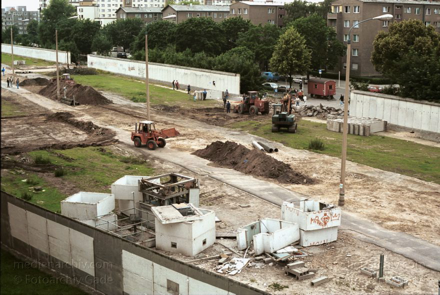 Berlin. Abbau der Berliner Mauer entlang der Bernauer Straße
15. Juni 1990. Berlin. Mitte. Wedding. DDR. Grenzstreifen entlang der Bernauer Straße. Seit Mittwoch. dem 13. 6. 1990. reissen Bautrupps entlang der gesamten Bernauer Straße die Mauer an verbauten Straßen ein. Bis zum 1. Juli sollen alle wieder passierbar sein. Obwohl an den Übergängen noch kontrolliert wird. kann man den Grenzstreifen überall betreten und ueberqueren.
Schlüsselwörter: Berlin;berlin wall;Berliner Mauer;Bernauer Straße;DDR;DDR Grenze;Deutsche Demokratische Republik;Deutschland;GDR;Germany;Grenze;iron curtain;Mauer;Mitte;Ostberlin;Ostzone;1990;Wachturm