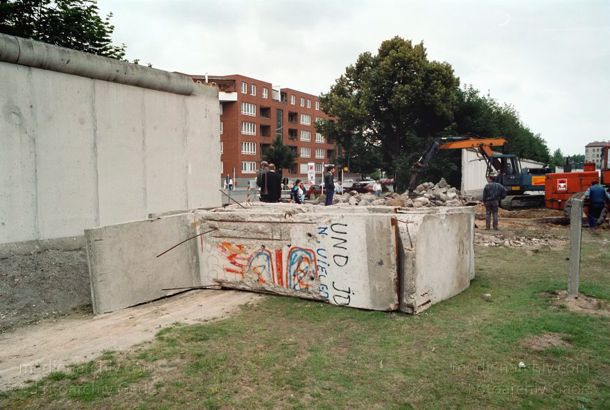 Berlin. Abbau der Berliner Mauer entlang der Bernauer Straße
15. Juni 1990. Berlin. Mitte. Wedding. DDR. Grenzstreifen entlang der Bernauer Straße. Seit Mittwoch. dem 13. 6. 1990. reissen Bautrupps entlang der gesamten Bernauer Straße die Mauer an verbauten Straßen ein. Bis zum 1. Juli sollen alle wieder passierbar sein. Obwohl an den Übergängen noch kontrolliert wird. kann man den Grenzstreifen überall betreten und ueberqueren.
Schlüsselwörter: Berlin;berlin wall;Berliner Mauer;Bernauer Straße;DDR;DDR Grenze;Deutsche Demokratische Republik;Deutschland;GDR;Germany;Grenze;iron curtain;Mauer;Mitte;Ostberlin;Ostzone;1990;Wachturm