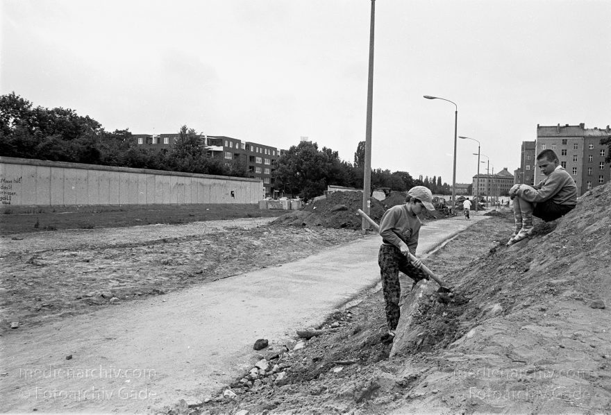 Berlin. Abbau der Berliner Mauer entlang der Bernauer Straße
15. Juni 1990. Berlin. Mitte. Wedding. DDR. Grenzstreifen entlang der Bernauer Straße. Seit Mittwoch. dem 13. 6. 1990. reissen Bautrupps entlang der gesamten Bernauer Straße die Mauer an verbauten Straßen ein. Bis zum 1. Juli sollen alle wieder passierbar sein. Obwohl an den Übergängen noch kontrolliert wird. kann man den Grenzstreifen überall betreten und ueberqueren.
Schlüsselwörter: Berlin;berlin wall;Berliner Mauer;Bernauer Straße;DDR;DDR Grenze;Deutsche Demokratische Republik;Deutschland;GDR;Germany;Grenze;iron curtain;Mauer;Mitte;Ostberlin;Ostzone;1990;Wachturm
