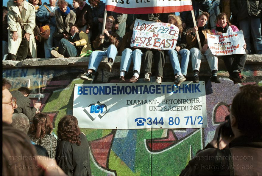 Menschen auf der Berliner Mauer vor dem Brandenburger Tor
10. November 1989. Berlin. Mitte. Tiergarten. Die DDR öffnet ihre Grenze. Menschen versammeln sich an der Mauer vor dem Brandenburger Tor.
Schlüsselwörter: Berlin;berlin wall;Berliner Mauer;DDR;DDR Grenze;Deutsche Demokratische Republik;Deutschland;GDR;Germany;Grenze;iron curtain;Mauer;Mitte;Ostberlin;1989;Ostzone