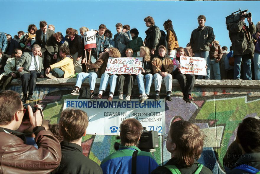 Menschen auf der Berliner Mauer vor dem Brandenburger Tor
10. November 1989. Berlin. Mitte. Tiergarten. Die DDR öffnet ihre Grenze. Menschen versammeln sich an der Mauer vor dem Brandenburger Tor.
Schlüsselwörter: Berlin;berlin wall;Berliner Mauer;DDR;DDR Grenze;Deutsche Demokratische Republik;Deutschland;GDR;Germany;Grenze;iron curtain;Mauer;Mitte;Ostberlin;1989;Ostzone