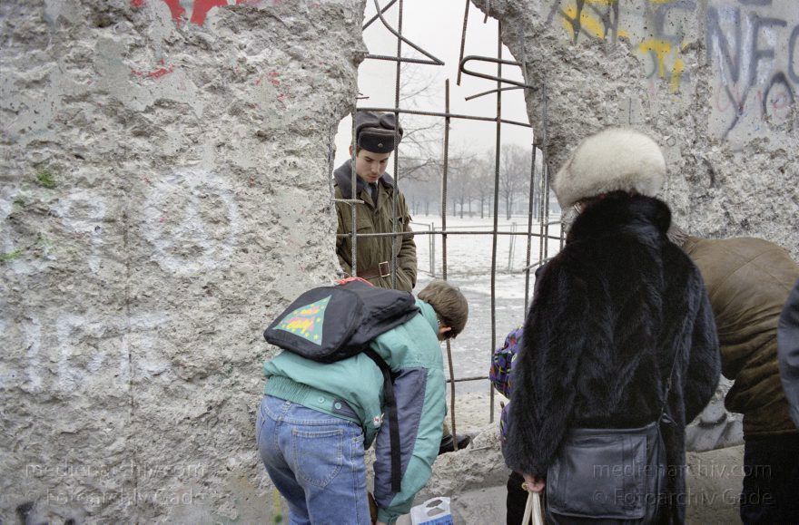 Lücke in der Berliner Mauer.
7. 1. 1990. Berlin. Mitte. Berliner Mauer beim Reichstag. DDR-Grenze zwischen Tiergarten und Mitte. Ein DDR Grenzposten und Besucher betrachten sich durch eine Lücke in der Mauer.
Schlüsselwörter: Berlin;berlin wall;Berliner Mauer;DDR;GDR;Germany;Grenze;Grenzposten;Mitte;1990;Ostberlin