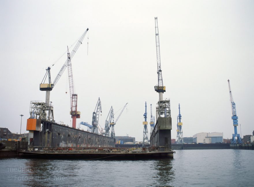 Deutschland. Freie und Hansestadt Hamburg. Hafen. Werft. Trockendock
April 1992. Deutschland. Freie und Hansestadt Hamburg. Hafen. Elbe. Schifffahrt. Schiffahrt. Seefahrt. Güterverkehr. Seetransport. Pier. Kaianlagen. Trockendock. Werft. 

Hamburg Harbour is a deep water harbour off the North Sea, on the river Elbe in Hamburg, Germany.
Schlüsselwörter: Deutschland;Elbe;Fluss;Frachter;Germany;Hafen;Hamburg;Kai;Schiffe;Seefahrt;Trockendock;1992;Werft