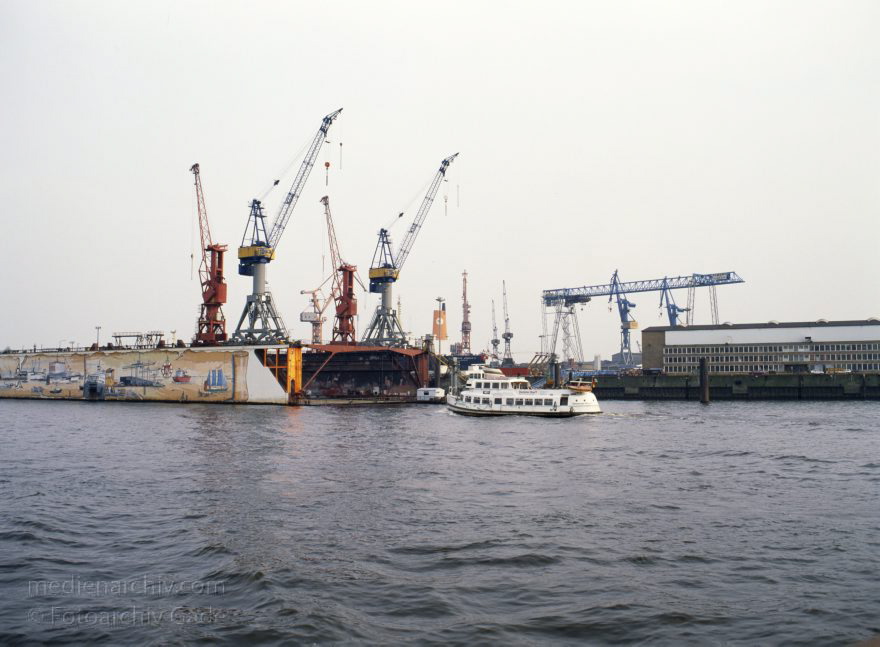 Deutschland. Freie und Hansestadt Hamburg. Hafen. Werft. Trockendock
April 1992. Deutschland. Freie und Hansestadt Hamburg. Hafen. Elbe. Schifffahrt. Schiffahrt. Seefahrt. Güterverkehr. Seetransport. Pier. Kaianlagen. Trockendock. Werft. 

Hamburg Harbour is a deep water harbour off the North Sea, on the river Elbe in Hamburg, Germany.
Schlüsselwörter: Deutschland;Elbe;Fluss;Frachter;Germany;Hafen;Hamburg;Kai;Schiffe;Seefahrt;Trockendock;1992;Werft