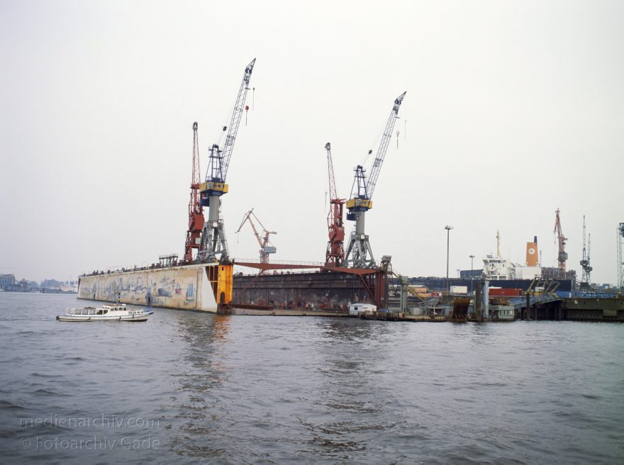 Deutschland. Freie und Hansestadt Hamburg. Hafen. Werft. Trockendock
April 1992. Deutschland. Freie und Hansestadt Hamburg. Hafen. Elbe. Schifffahrt. Schiffahrt. Seefahrt. Güterverkehr. Seetransport. Pier. Kaianlagen. Trockendock. Werft. 

Hamburg Harbour is a deep water harbour off the North Sea, on the river Elbe in Hamburg, Germany.
Schlüsselwörter: Deutschland;Elbe;Fluss;Frachter;Germany;Hafen;Hamburg;Kai;Schiffe;Seefahrt;Trockendock;1992;Werft