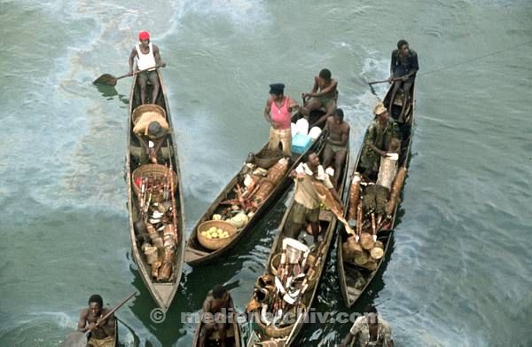 1975. Südafrika. Afrikaner mit Waren in Booten im Hafen. Verkäufer.