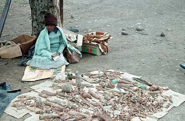 1975. Südafrika. Frau mit einem Verkaufsstand. Waren auf einer Decke