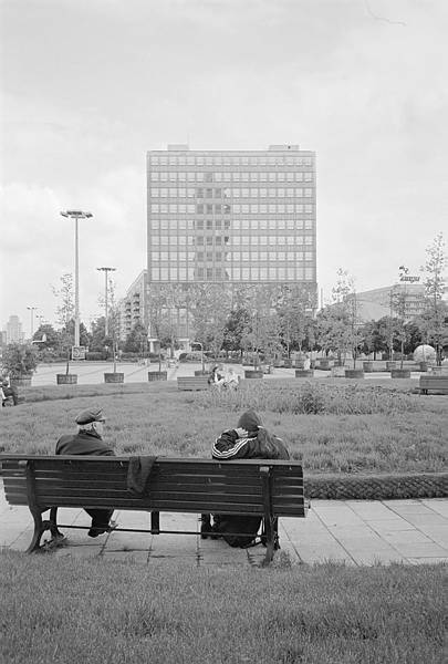 4. Juni 1990. Berlin. Berlin-Mitte. Alexanderplatz. Leute auf einer Bank. Haus des Lehrers.