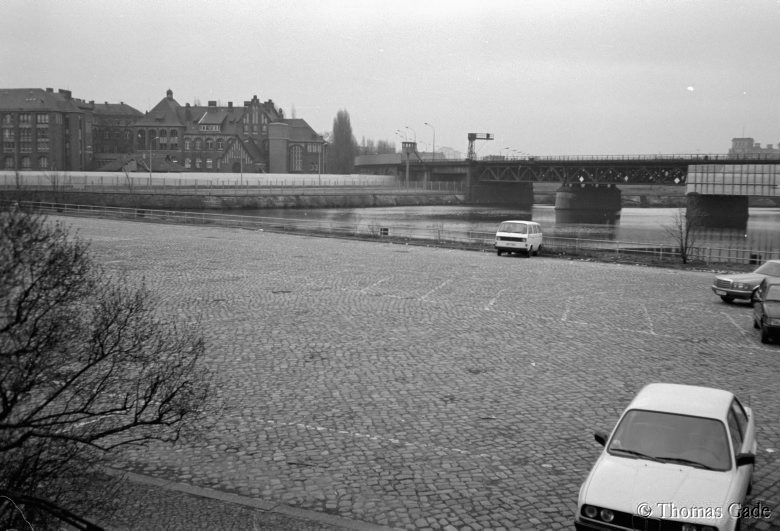 13. 2. 1990. Berlin. Tiergarten. Humboldthafen beim Lehrter Bahnhof. Parkplatz. Hinten: Berliner Mauer vor dem Krankenhaus Charité