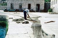 1959. Kroatien ( Jugoslawien)  Insel Lošinj. Losinj  (deutsch veraltet: Lötzing. italienisch: Lussino)  Kroatische Insel in der Adria. Ein Fischer flickt seine Netze im Hafen. Croatia (Yugoslavia )