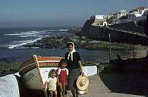 1963. Portugal. Strand. Meer. Frau vor einem Fischerboot. Kinder