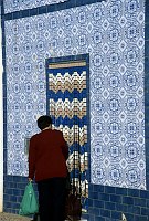 November 2000. <br>Portugal. Tavira. Fliesen an einer Hausfassade. Frau mit Einkäufen vor dem Eingang.