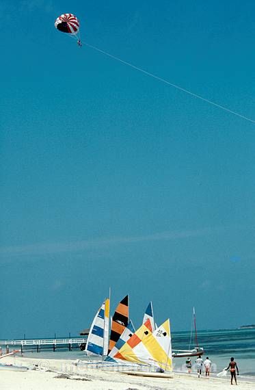 1978. Caribbean. Karibik. Bahamas. Nassau. Meer. Boote. Segelboote. Parasailing an einem Fallschirm. Strand