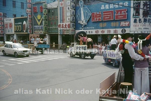 1974. Asien. Hongkong. The World Surprise Show. Die Darsteller fahren in offenen Autos und präsentieren sich.