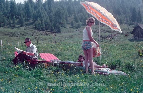 1975. Unter einem Sonnenschirm auf einer Wiese