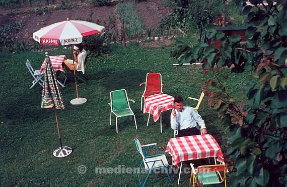 1969. Berlin. Garten. Sonnenschirm. Man auf einem Stuhl