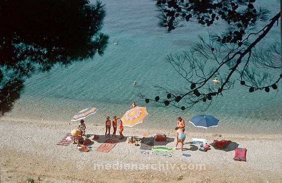 1975. Portugal. Küste. Meer. Atlantik. Urlaub am Strand. Sonnenschirme. Sonnen