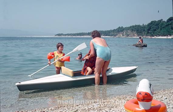 1975. Portugal. Küste. Meer. Atlantik. Mutter mit Kindern an einem Kajak. Boote