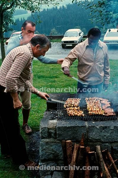 1981. Bayern. Drei Männer grillen. Barbecue
