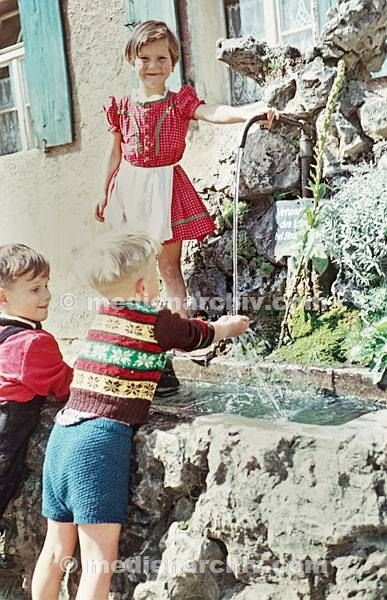 September 1952. Deutschland. Bayern. Eschenbach. Germany. Bavaria. Kinder spielen an einem Brunndn